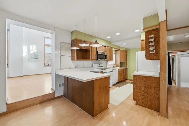 a kitchen with stainless steel appliances kitchen island a refrigerator sink and stove