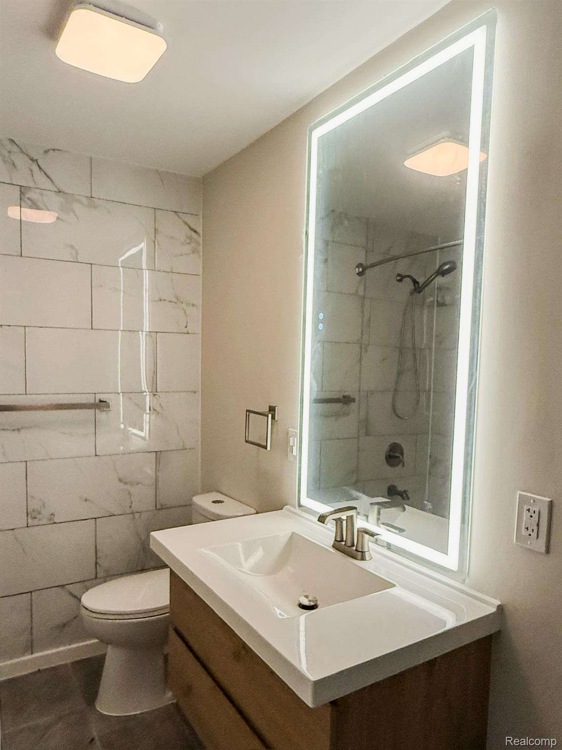 30052 Schoenherr Road Warren, MI 48088 - Photo 25 of 38 Bathroom vanity featuring an integrated sink, brushed nickel faucet, and a lighted mirror