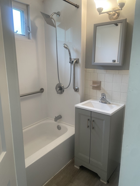 21 Arbor Lane, Unit 21 Dedham, MA 02026 - Photo 3 of 10 a bathroom with a bathtub a sink a vanity and a mirror
