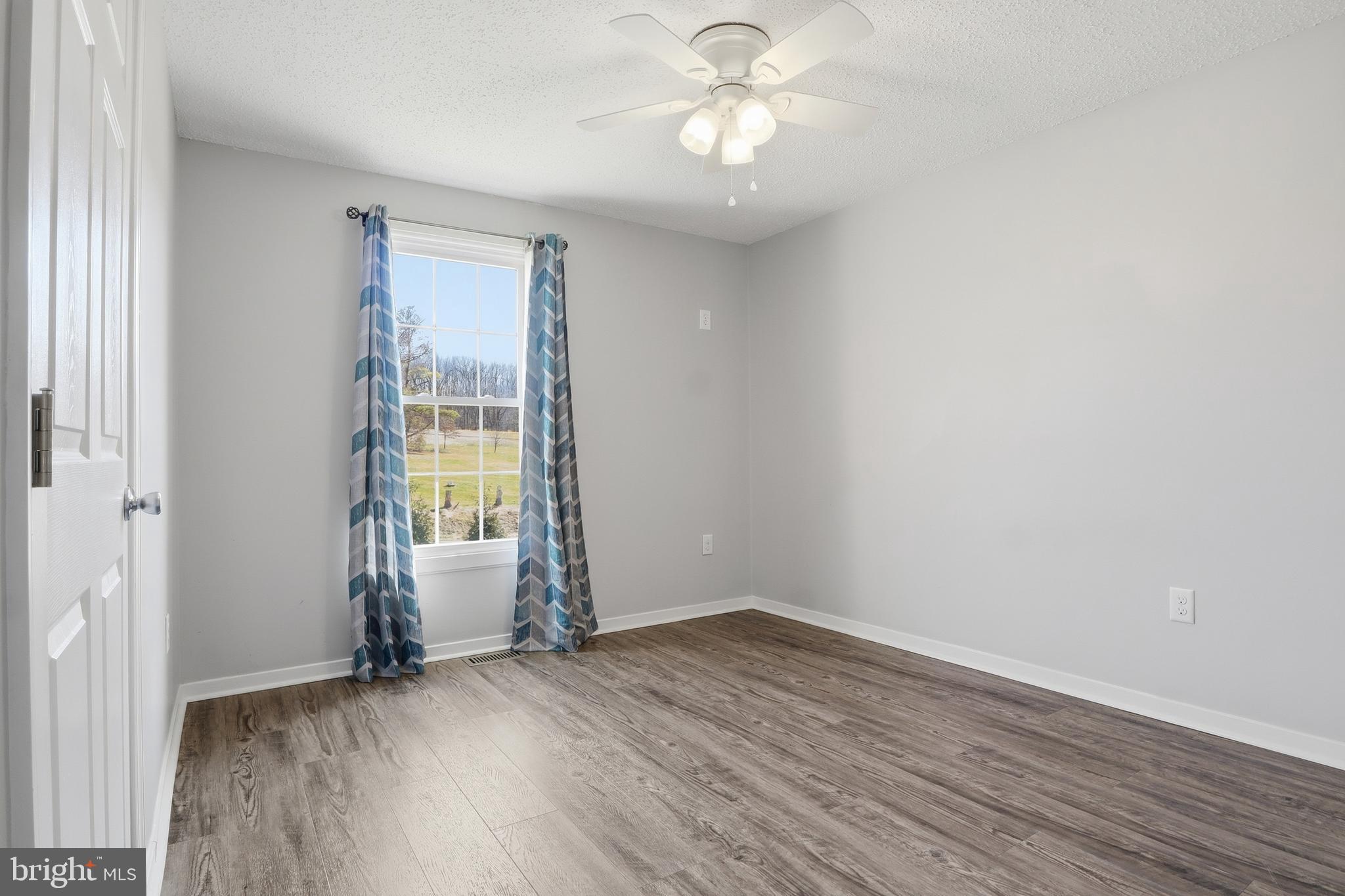 339 Lay Road Delta, PA 17314 - Photo 23 of 60 an empty room with wooden floor and windows