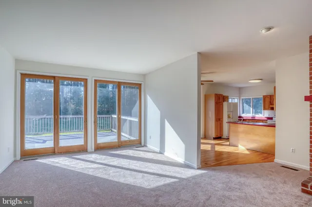 a view of empty room with wooden floor and floor to ceiling window