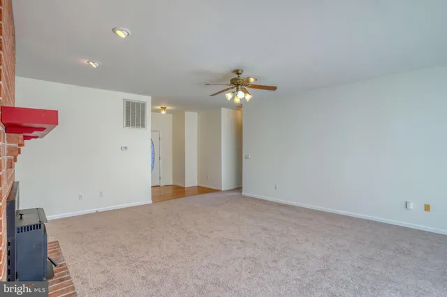 a view of an empty room with a chandelier fan