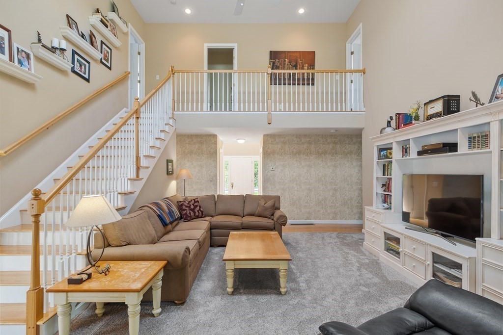 2 Gullane Road Hooksett, NH 03106 - Photo 12 of 27 a living room with furniture a flat screen tv and a fireplace