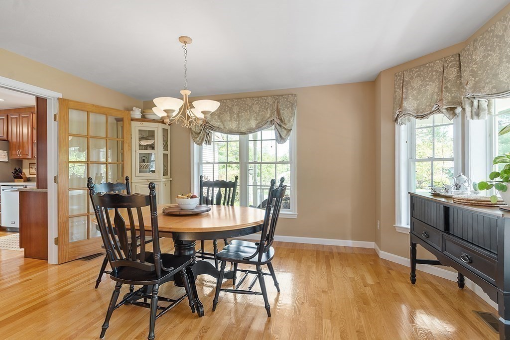 2 Gullane Road Hooksett, NH 03106 - Photo 16 of 27 a dining room with wooden floor a chandelier a wooden table and chairs