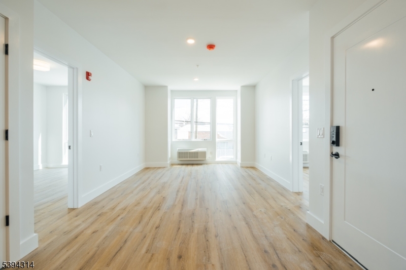 67 Summer Avenue, Unit 202 Newark, NJ 07104 - Photo 12 of 26 a view of an empty room with wooden floor and a window