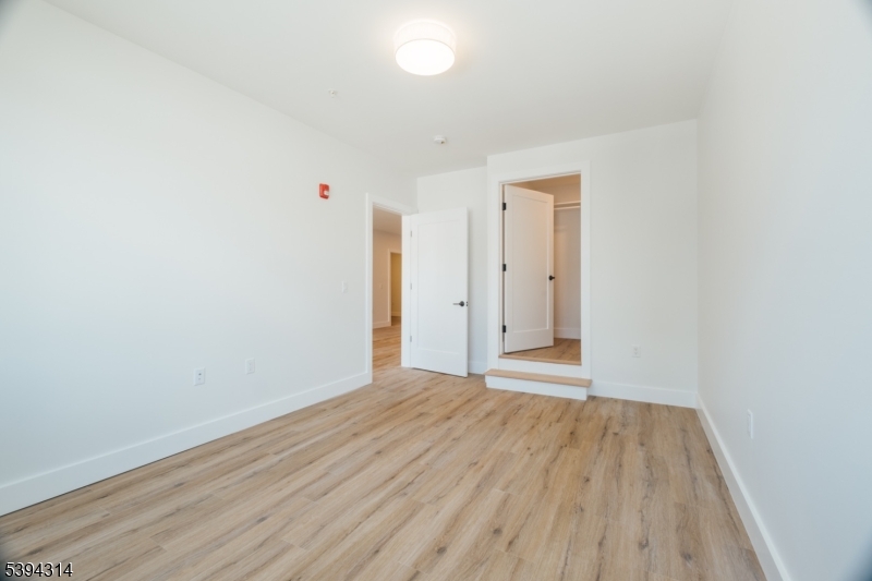 67 Summer Avenue, Unit 202 Newark, NJ 07104 - Photo 18 of 26 a view of an empty room with wooden floor and a window