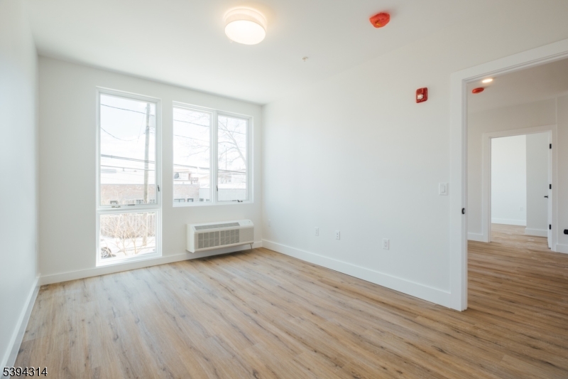 67 Summer Avenue, Unit 202 Newark, NJ 07104 - Photo 10 of 26 an empty room with wooden floor and windows