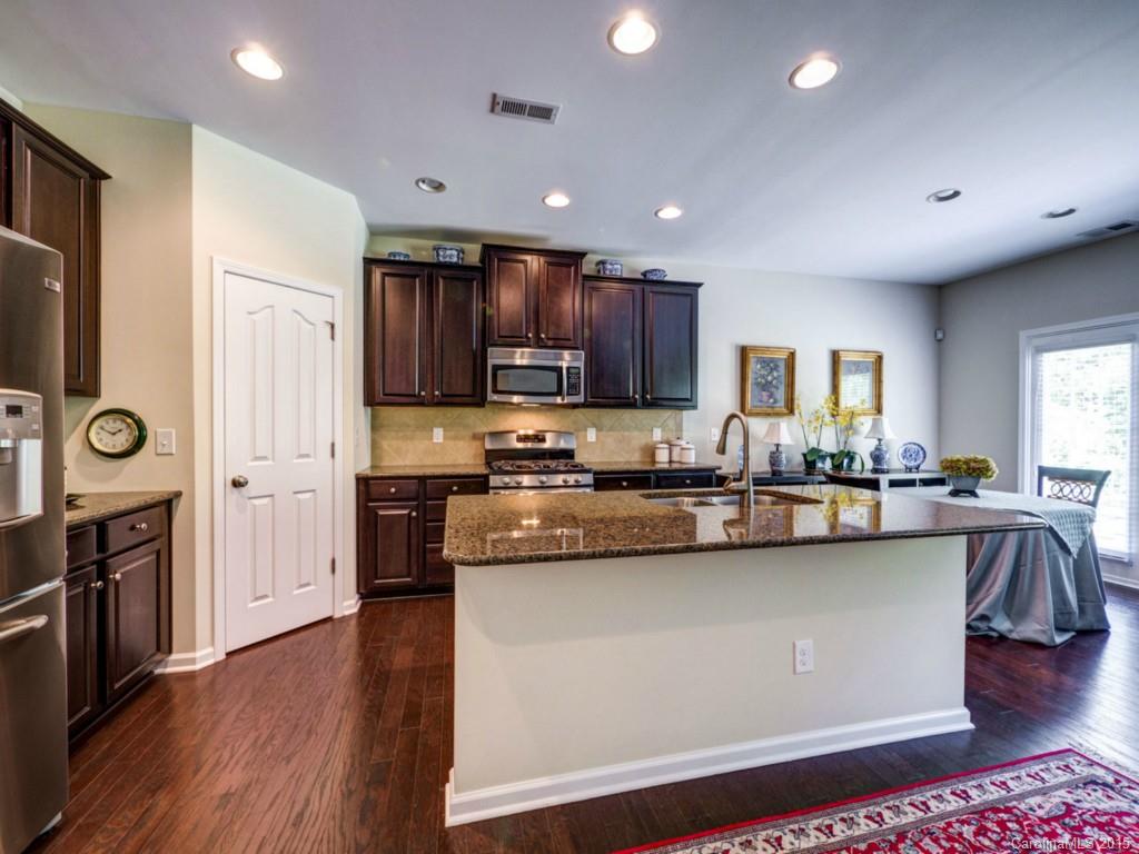 16854 Rudence Court Charlotte, NC 28278 - Photo 4 of 23 a kitchen with stainless steel appliances granite countertop a refrigerator a stove top oven a sink dishwasher and white cabinets with wooden floor