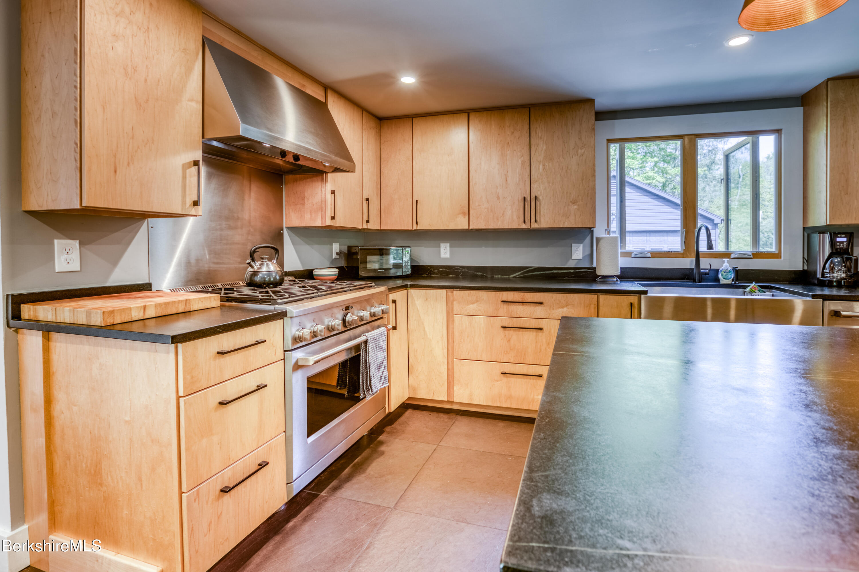 6 Lake Buel Road Great Barrington, MA 01230 - Photo 15 of 38 a kitchen with stainless steel appliances granite countertop a stove a sink a refrigerator and white cabinets with wooden floor