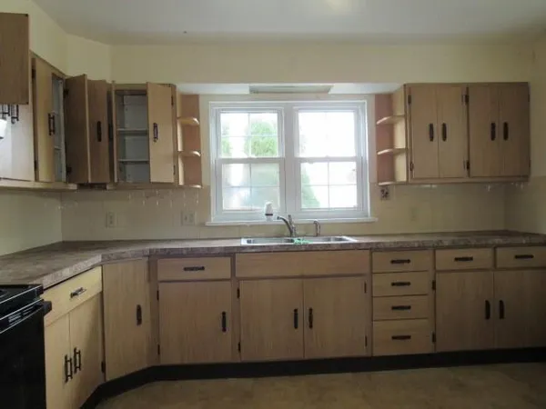 a kitchen with stainless steel appliances granite countertop white cabinets sink and window