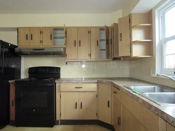 a kitchen with cabinets appliances a sink and a window