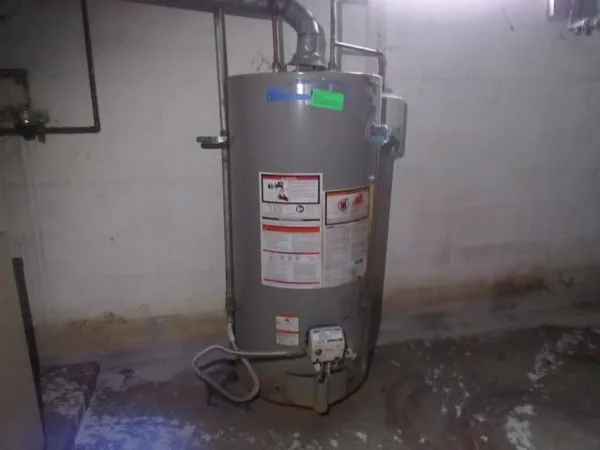 a room with water heater and wooden cabinets