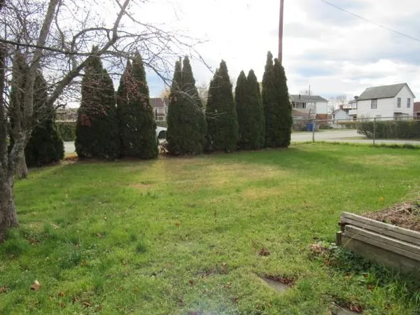 a view of a green field with wooden fence