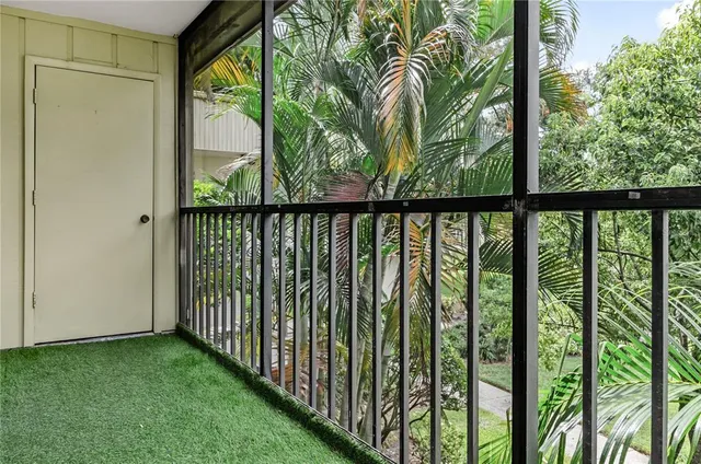 a view of a porch with a floor to ceiling window next to a yard