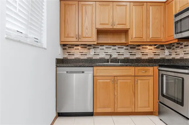 a kitchen with granite countertop white cabinets and stainless steel appliances