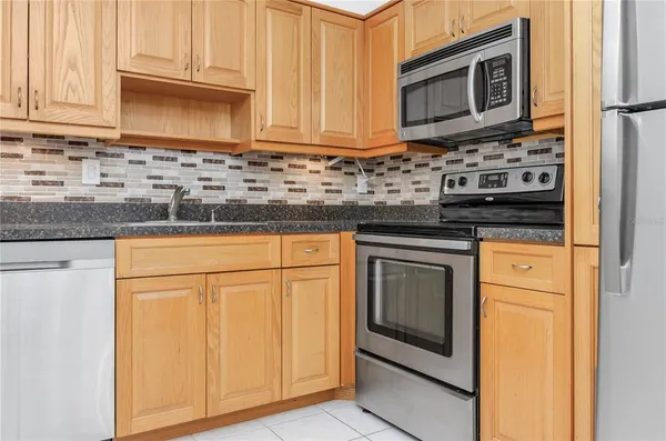 a kitchen with granite countertop cabinets stainless steel appliances and a sink