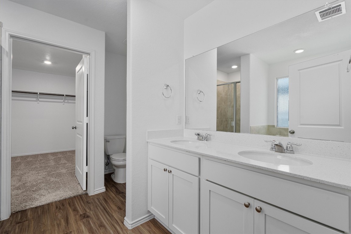 3213 Ancira Place Pflugerville, TX 78660 - Photo 15 of 30 a bathroom with a double vanity sink mirror and shower