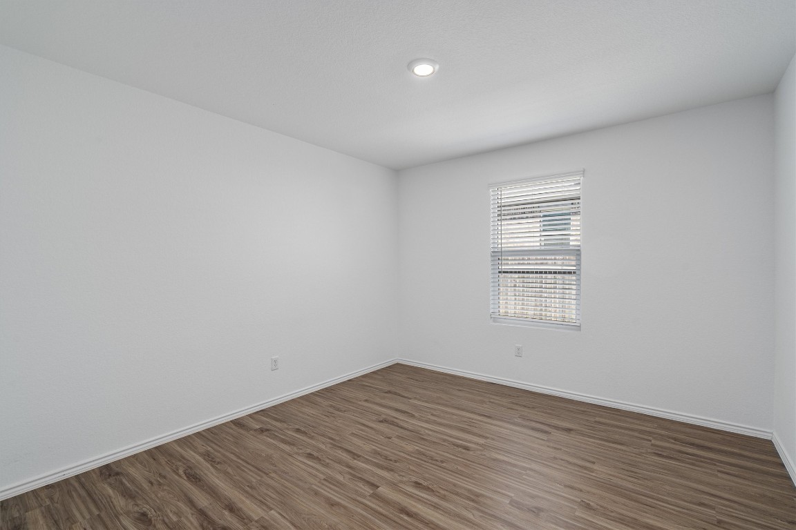 3213 Ancira Place Pflugerville, TX 78660 - Photo 26 of 30 an empty room with wooden floor and windows