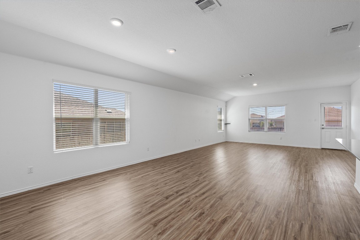 3213 Ancira Place Pflugerville, TX 78660 - Photo 5 of 30 an empty room with wooden floor and windows
