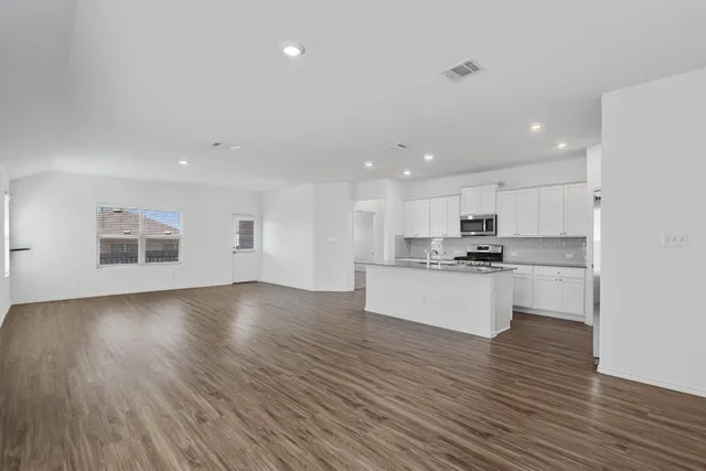 a view of kitchen with wooden floor and electronic appliances