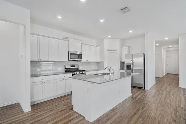 a kitchen with refrigerator a sink and wooden cabinets