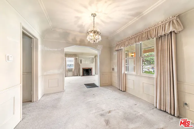 a view of a hallway with windows and chandelier