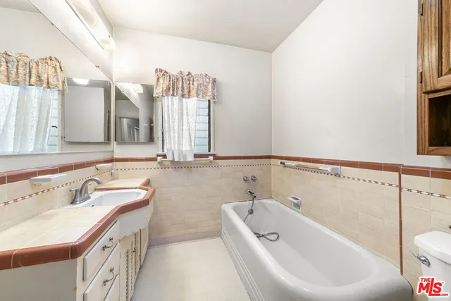 a bathroom with a tub sink and mirror