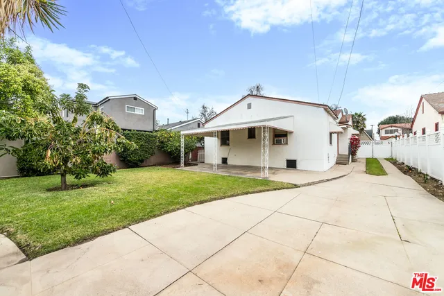 a backyard of a house with table and chairs