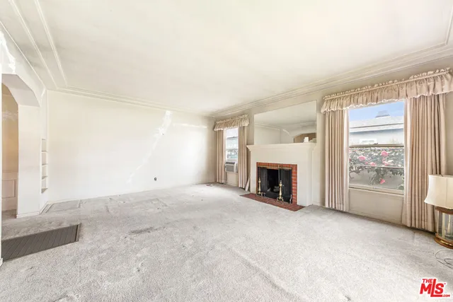 a view of a livingroom with a fireplace and window
