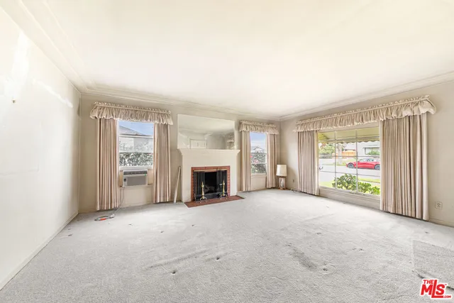 a view of an empty room with a fireplace and a window