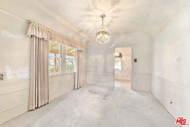 a view of a big room with windows and chandelier
