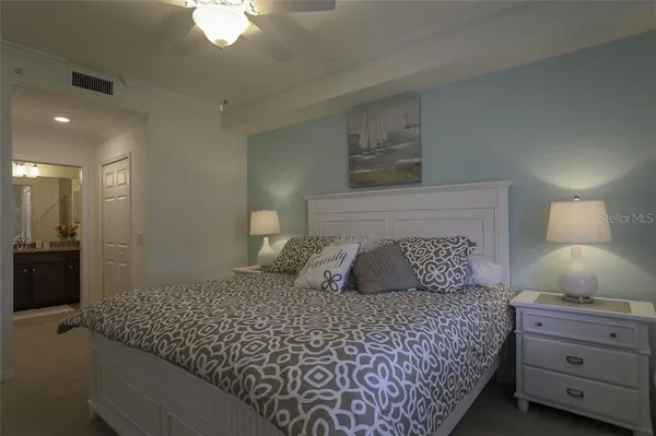 a bedroom with a large bed and a chandelier