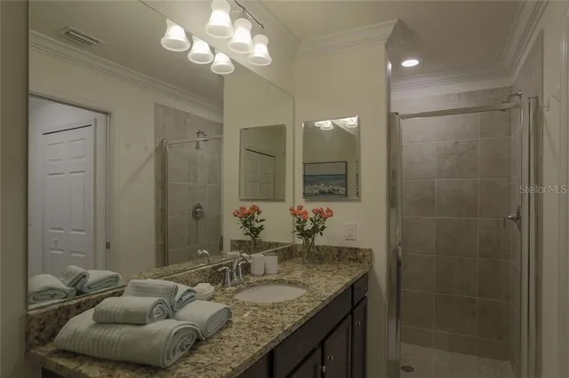a bathroom with a granite countertop sink a light fixture and a mirror