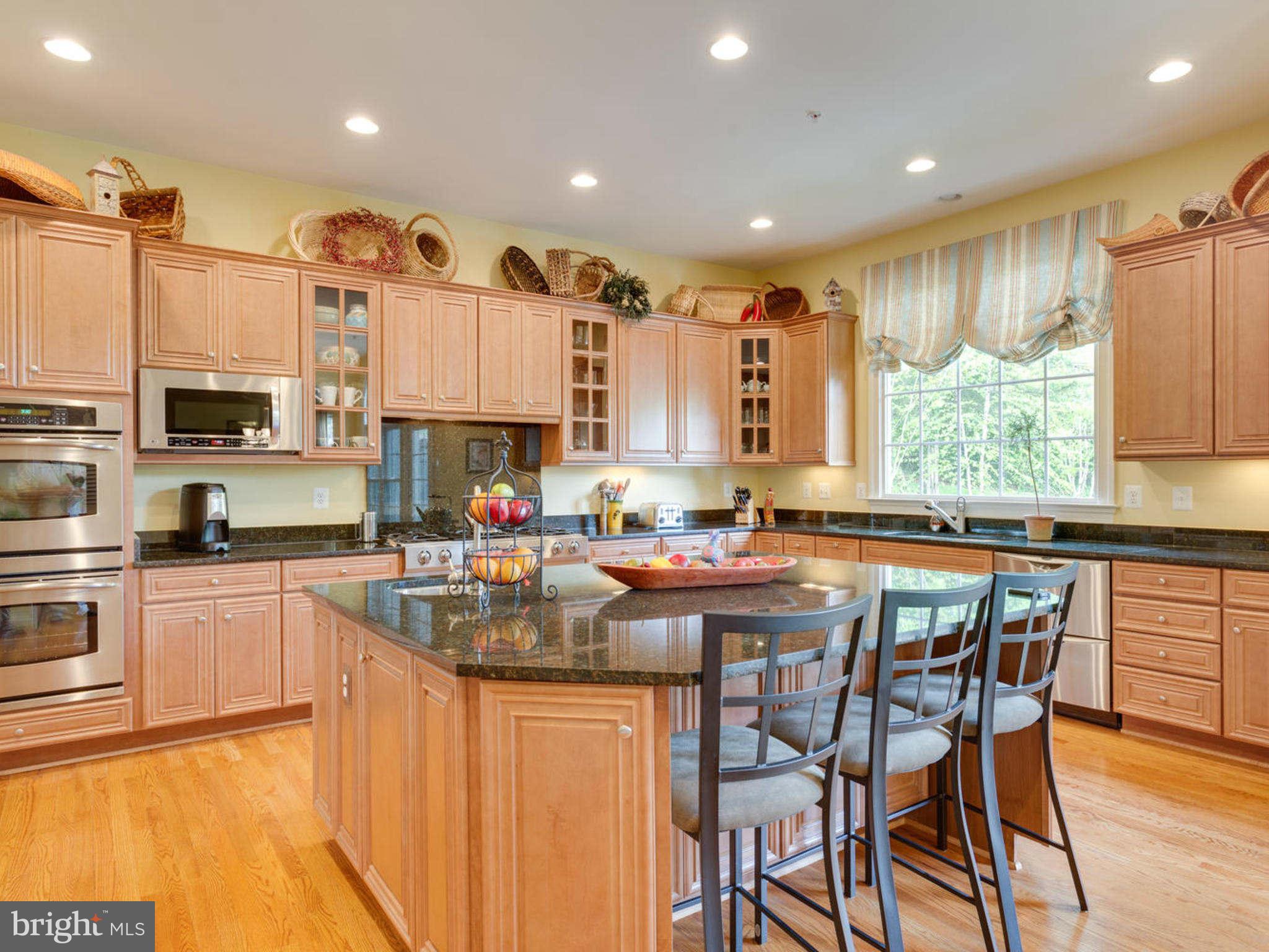 9208 Jones Mill Road Chevy Chase, MD 20815 - Photo 11 of 30 a kitchen with stainless steel appliances granite countertop wooden cabinets a stove top oven a sink and dishwasher