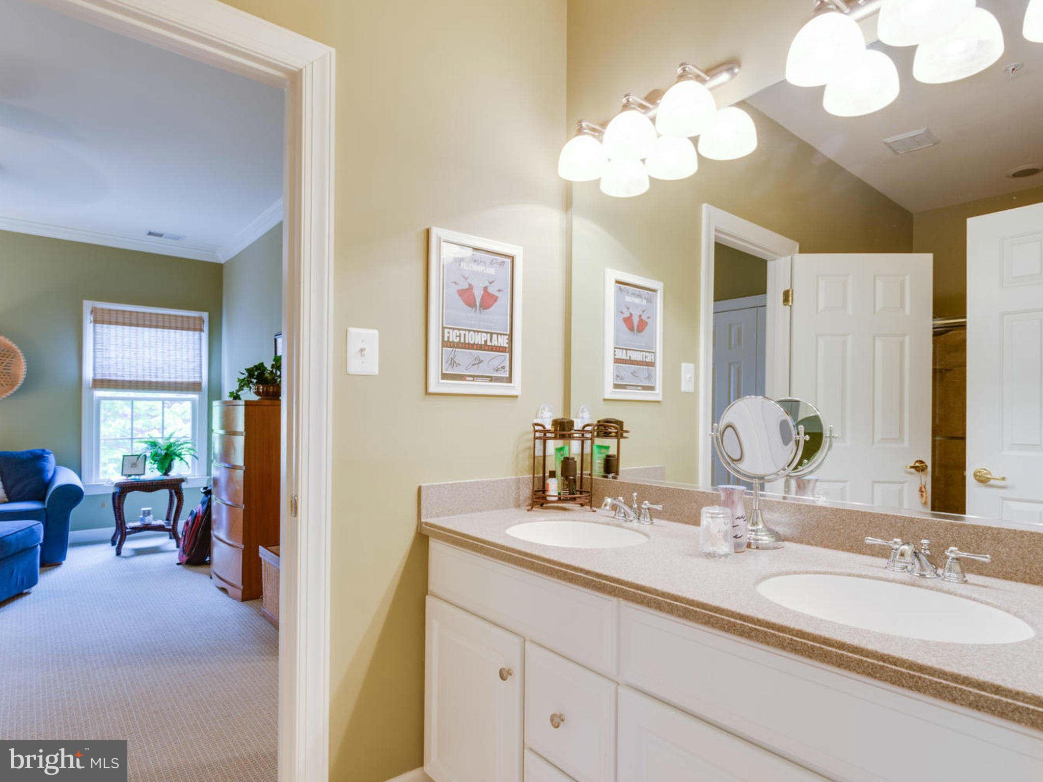 9208 Jones Mill Road Chevy Chase, MD 20815 - Photo 22 of 30 a bathroom with a granite countertop sink a large mirror and a shower