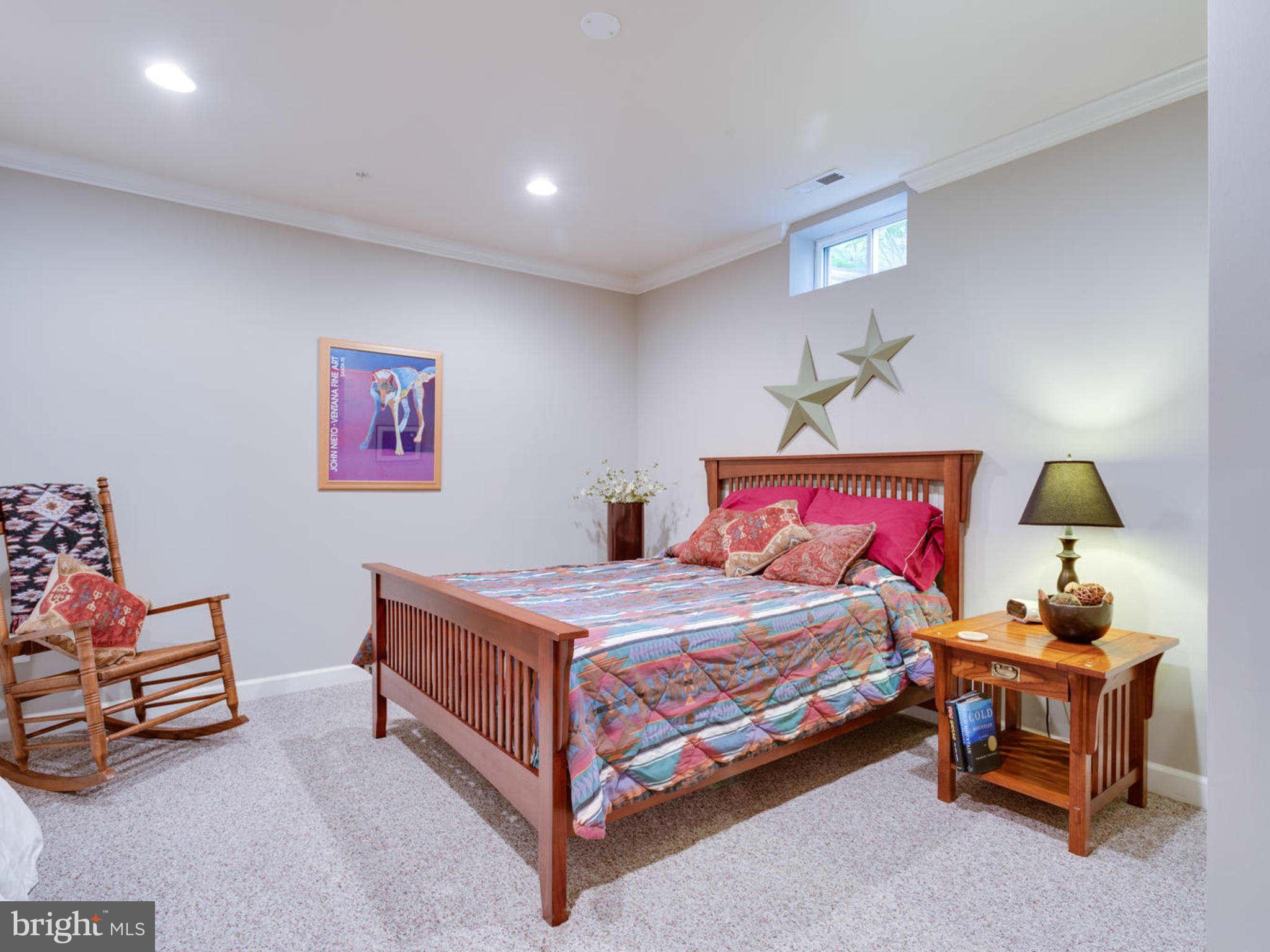 9208 Jones Mill Road Chevy Chase, MD 20815 - Photo 28 of 30 a bedroom with a bed and a chandelier