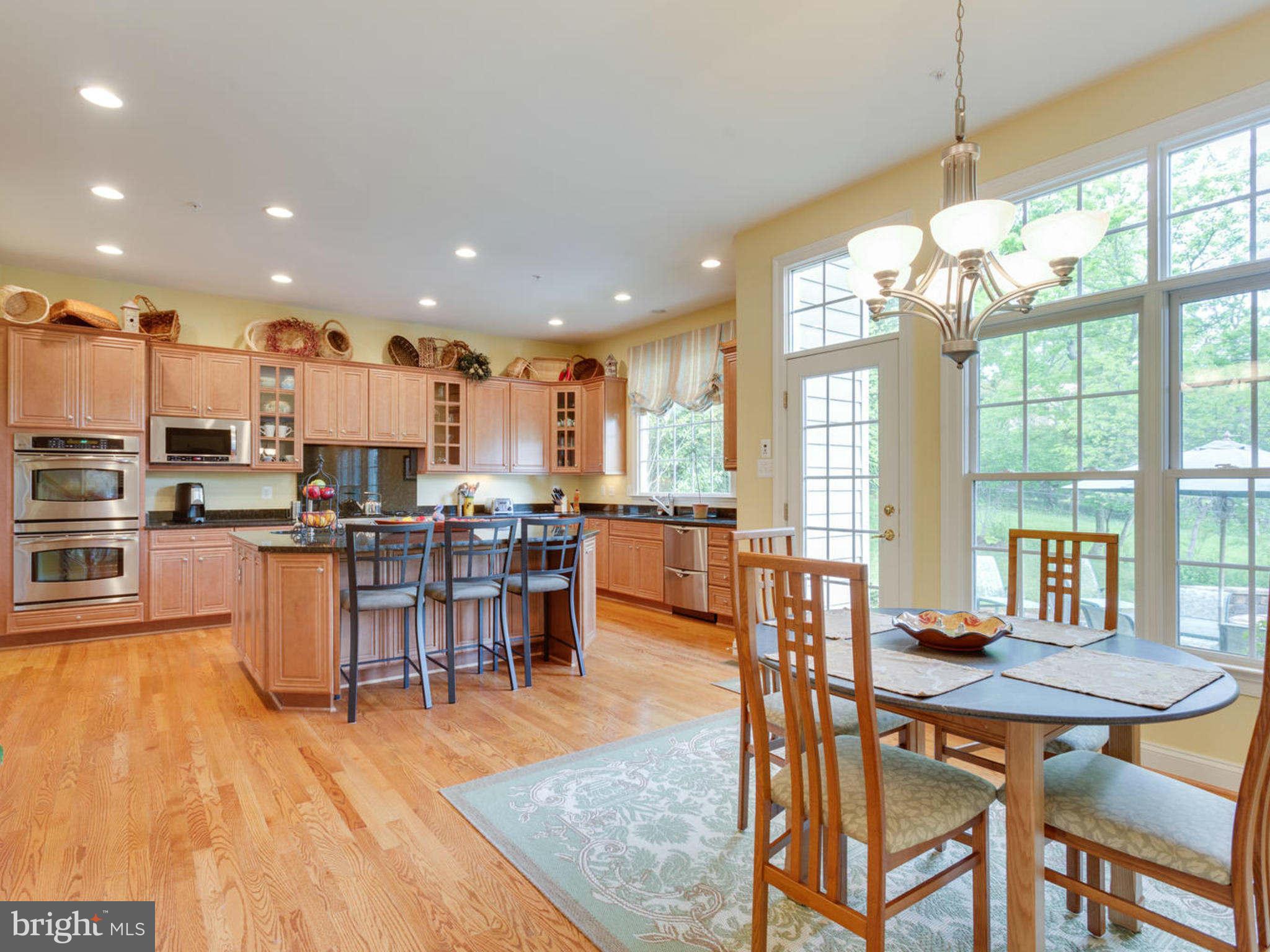 9208 Jones Mill Road Chevy Chase, MD 20815 - Photo 10 of 30 a open kitchen with stainless steel appliances granite countertop a stove top oven a dining table and chairs