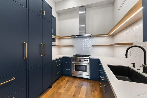 a kitchen with stainless steel appliances granite countertop a stove a sink and a refrigerator