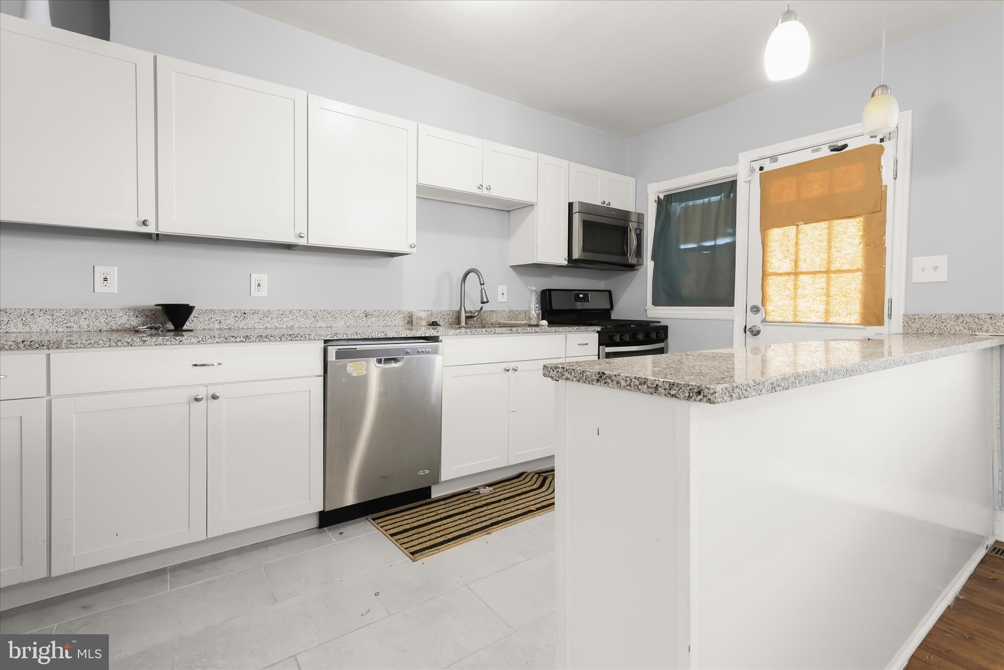 1504 North Linwood Avenue Baltimore, MD 21213 - Photo 10 of 29 a kitchen with granite countertop white cabinets sink and stainless steel appliances