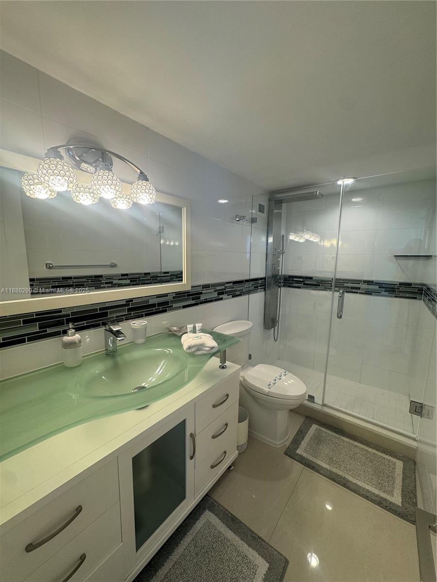5161 Collins Avenue, Unit 514 Miami Beach, FL 33140 - Photo 15 of 34 a bathroom with a toilet sink and mirror