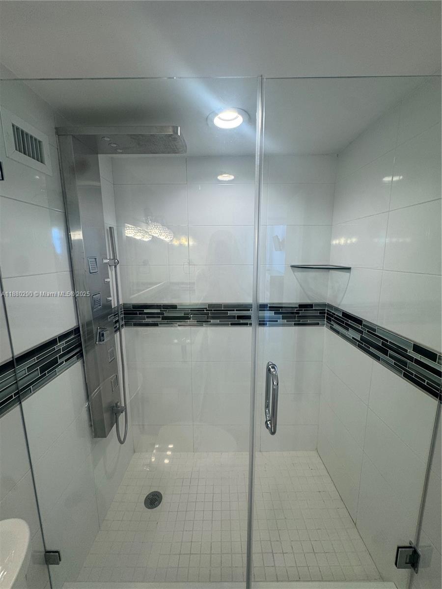 5161 Collins Avenue, Unit 514 Miami Beach, FL 33140 - Photo 16 of 34 a bathroom with a shower and a tub