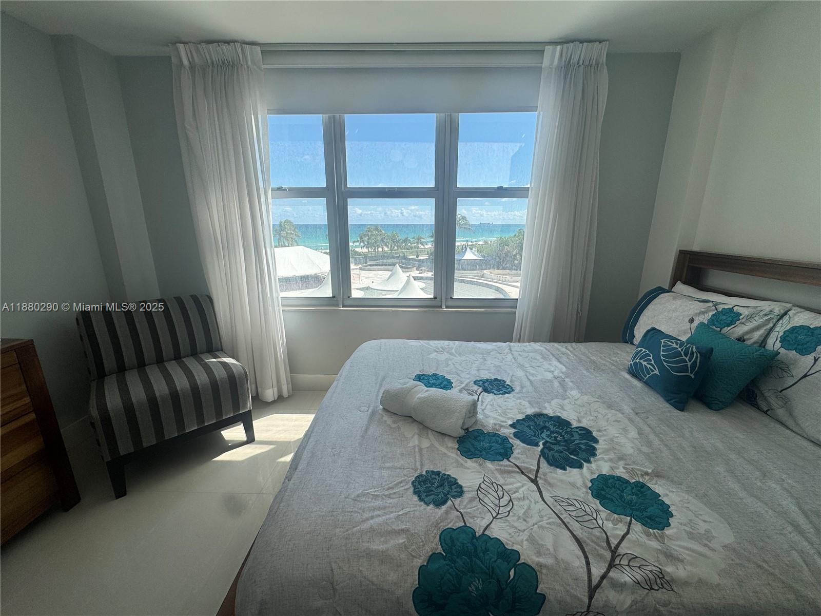 5161 Collins Avenue, Unit 514 Miami Beach, FL 33140 - Photo 18 of 34 a bedroom with a bed and a couch next to a window