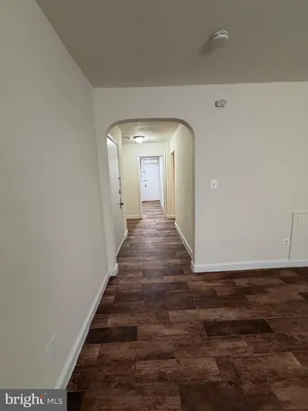 a view of a hallway with wooden floor and entryway