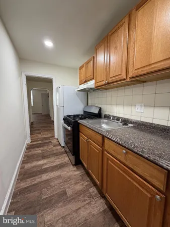 a kitchen with granite countertop wooden cabinets stainless steel appliances and a counter space
