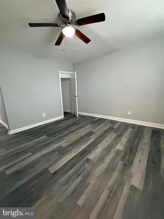 en empty room with ceiling fan and window
