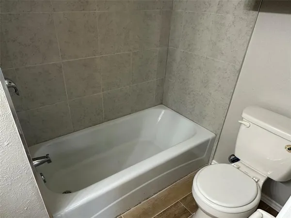a white bath tub sitting next to a toilet