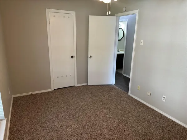 a view of an empty room with a cabinet and mirror