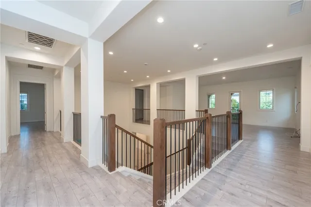 a view of a hallway with wooden floor and windows