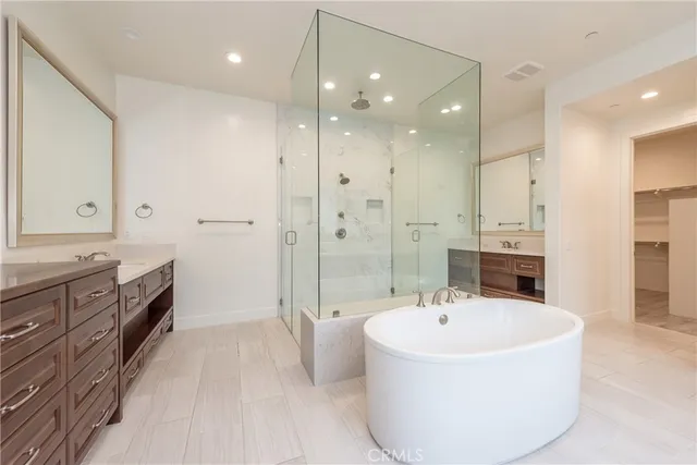 a bathroom with a tub sink shower and mirror