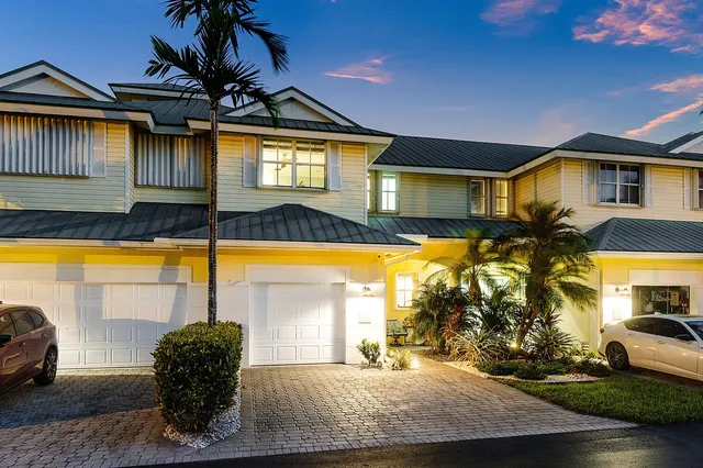 a front view of a house with a yard and potted plants